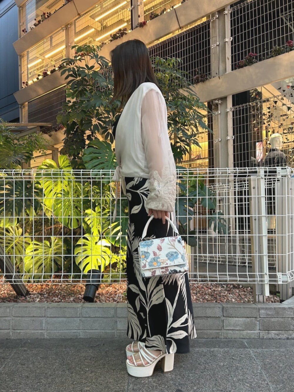 ブラック系のワンピース、ベージュ系のシャツ/ブラウス、ホワイト系のショルダーバッグを着用したレディースの夏コーディネートの3枚目の写真