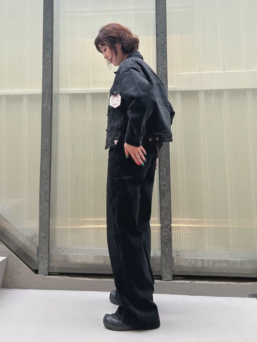 ブルー系のデニムパンツ、ホワイト系のキャミソール、ブルー系のデニムジャケットを着用したレディースの夏コーディネートの3枚目の写真