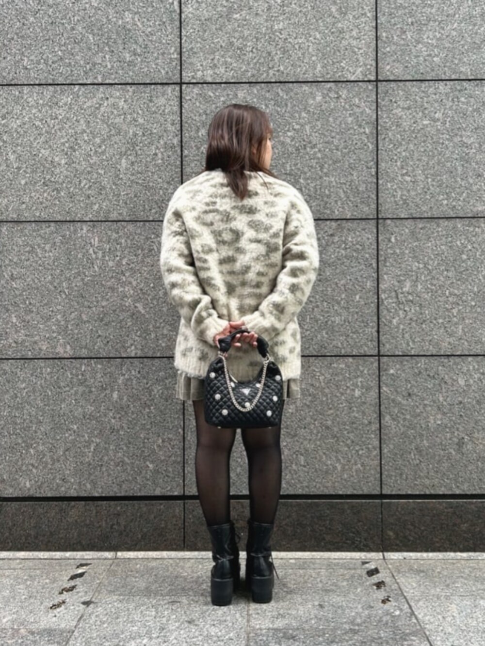 ブラック系のショルダーバッグ、その他のカーディガン/ボレロ、ベージュ系のスカートを着用したレディースの秋コーディネートの2枚目の写真