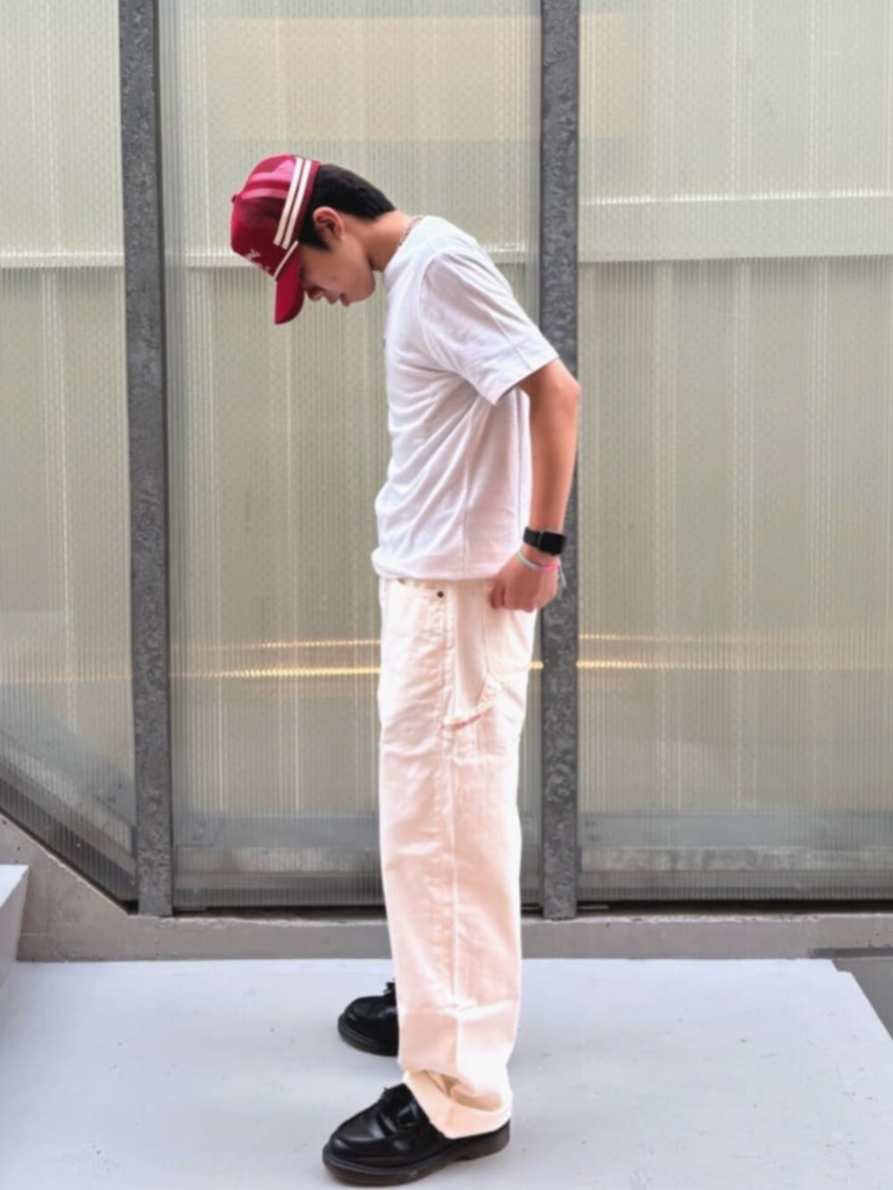 ホワイト系のTシャツ/カットソー、ホワイト系のカーゴパンツ、オレンジ系のキャップを着用したメンズの秋コーディネートの3枚目の写真