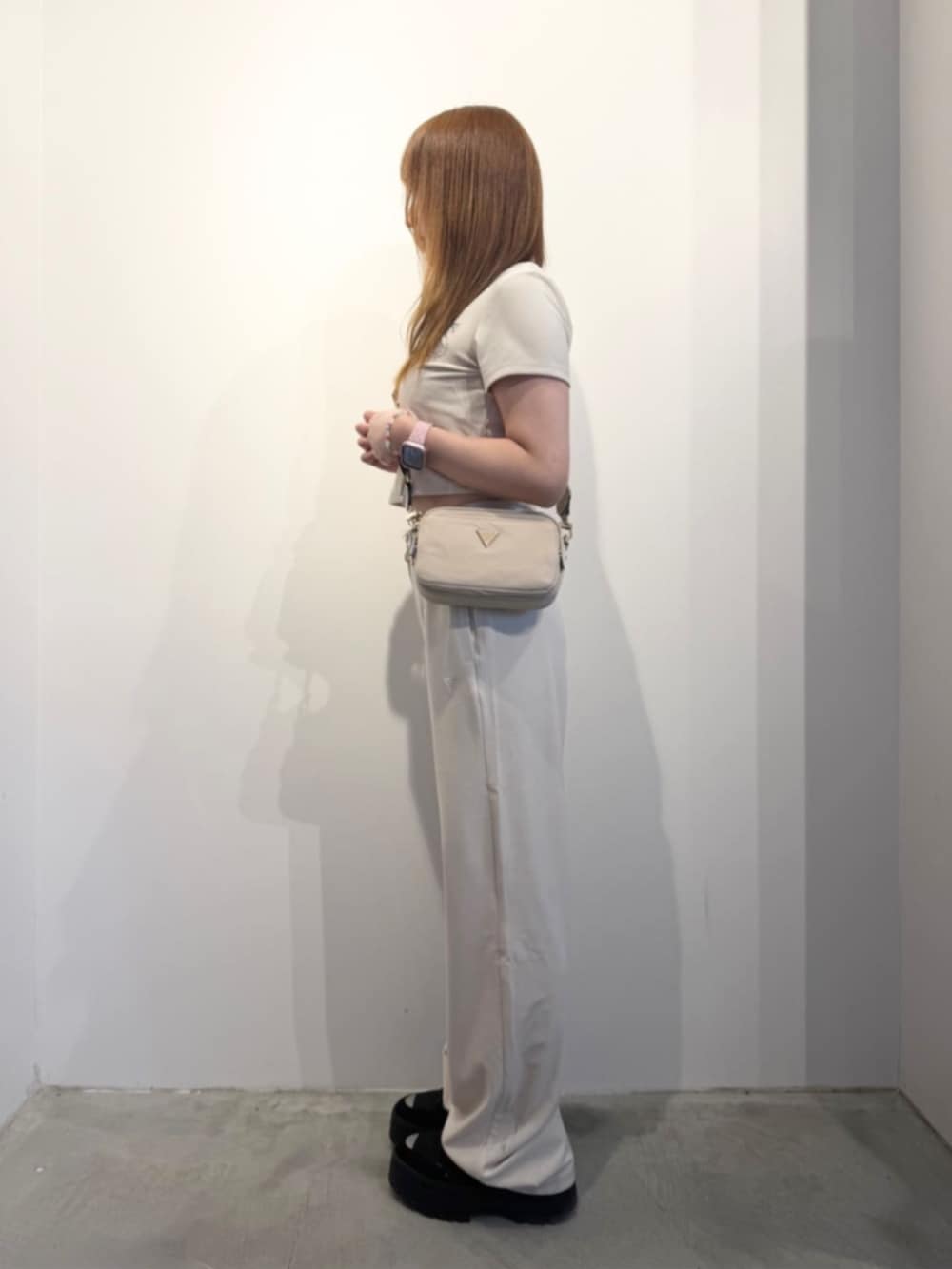 ベージュ系のショルダーバッグ、ホワイト系のTシャツ/カットソー、ホワイト系のスウェットパンツを着用したレディースの春コーディネートの3枚目の写真