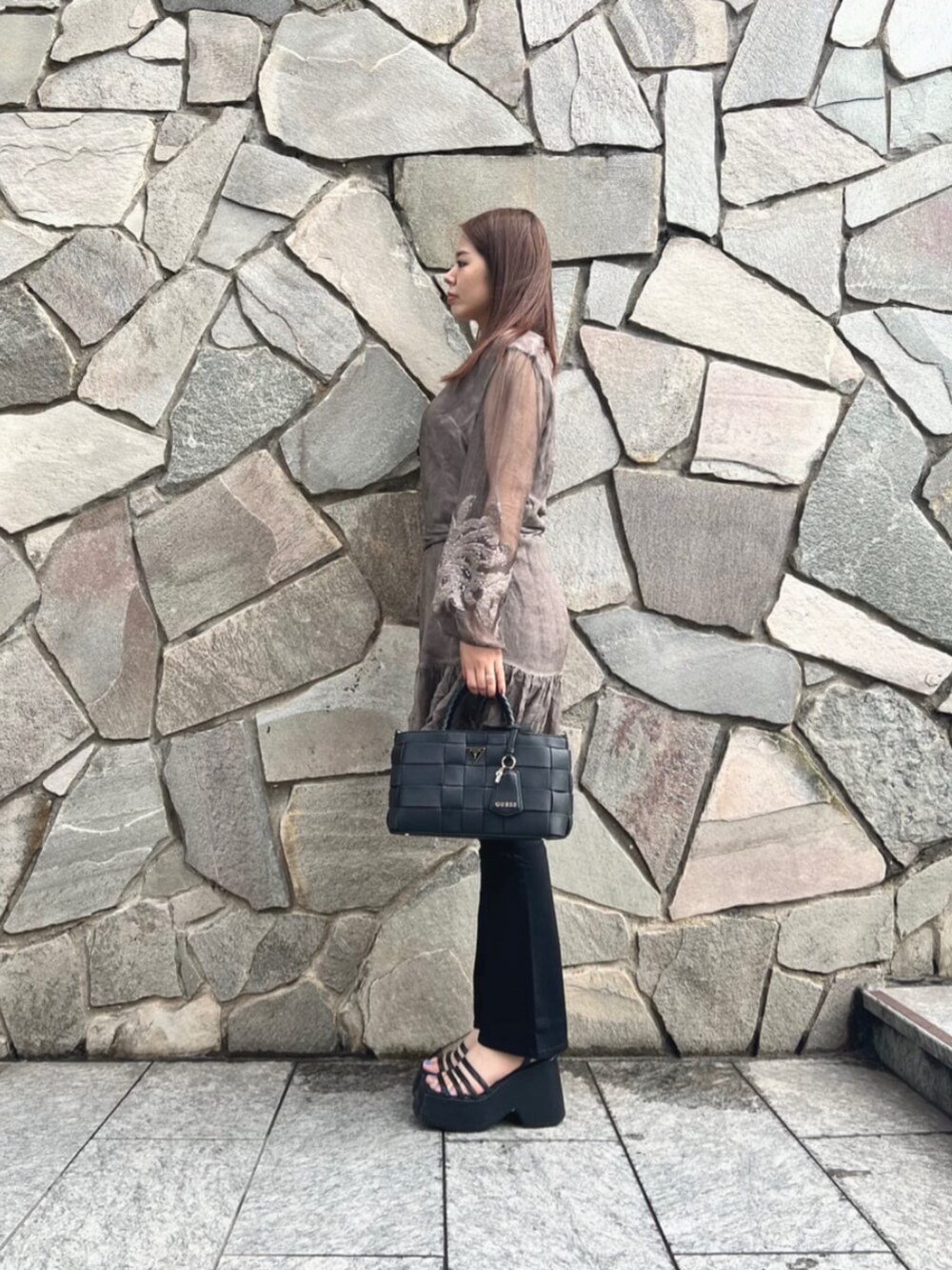 ブラウン系のワンピース、ブラック系のデニムパンツ、ブラック系のショルダーバッグを着用したレディースの秋コーディネートの3枚目の写真