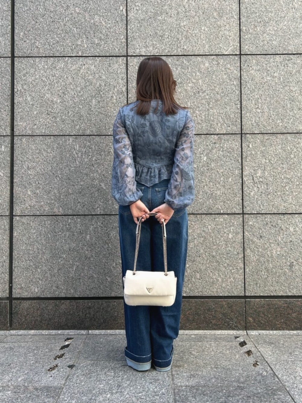 ブルー系のデニムパンツ、ブルー系のシャツ/ブラウス、ホワイト系のショルダーバッグを着用したレディースの秋コーディネートの2枚目の写真