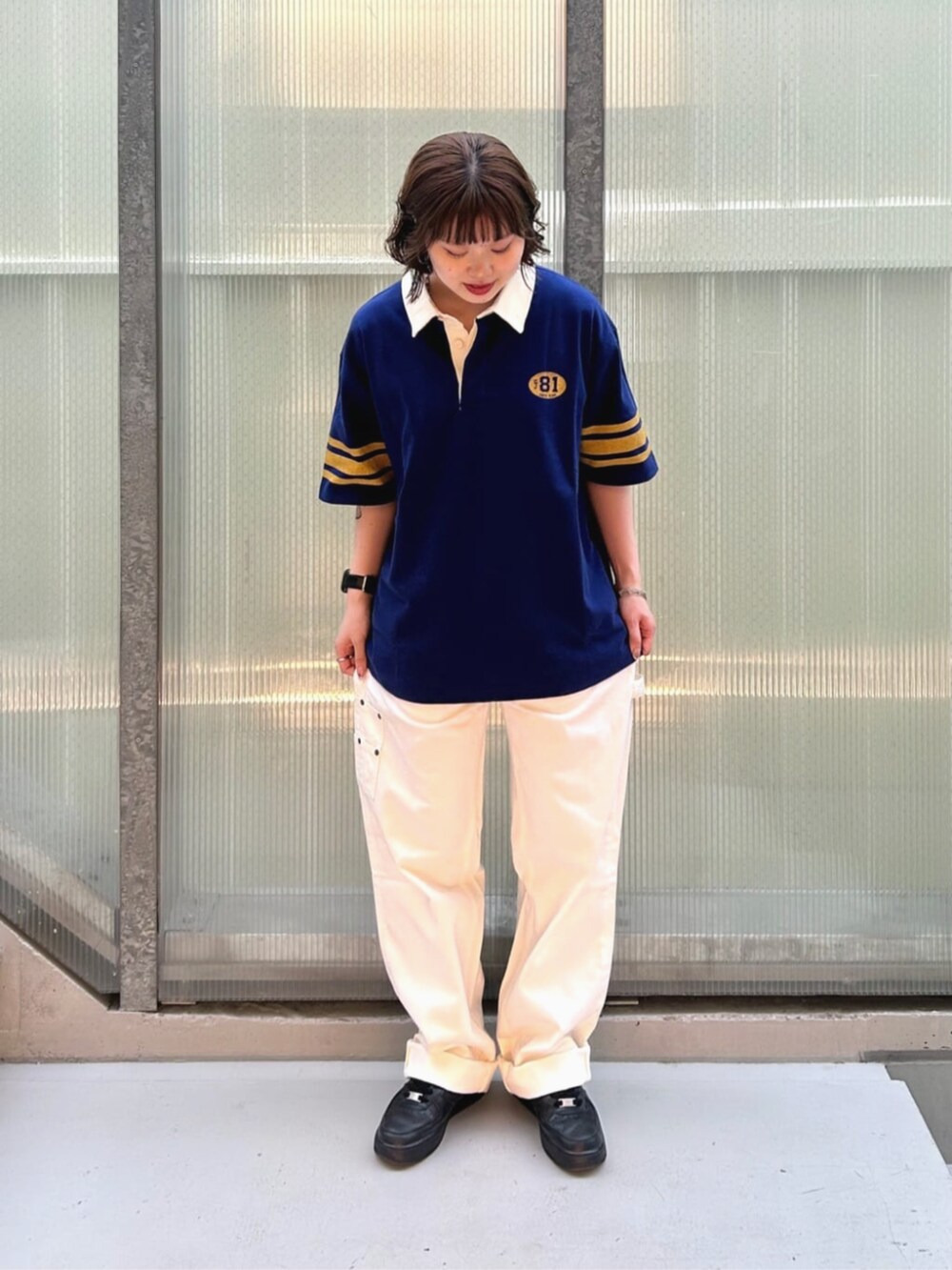 ブルー系のポロシャツ、ホワイト系のカーゴパンツを着用したレディースの秋コーディネートの4枚目の写真