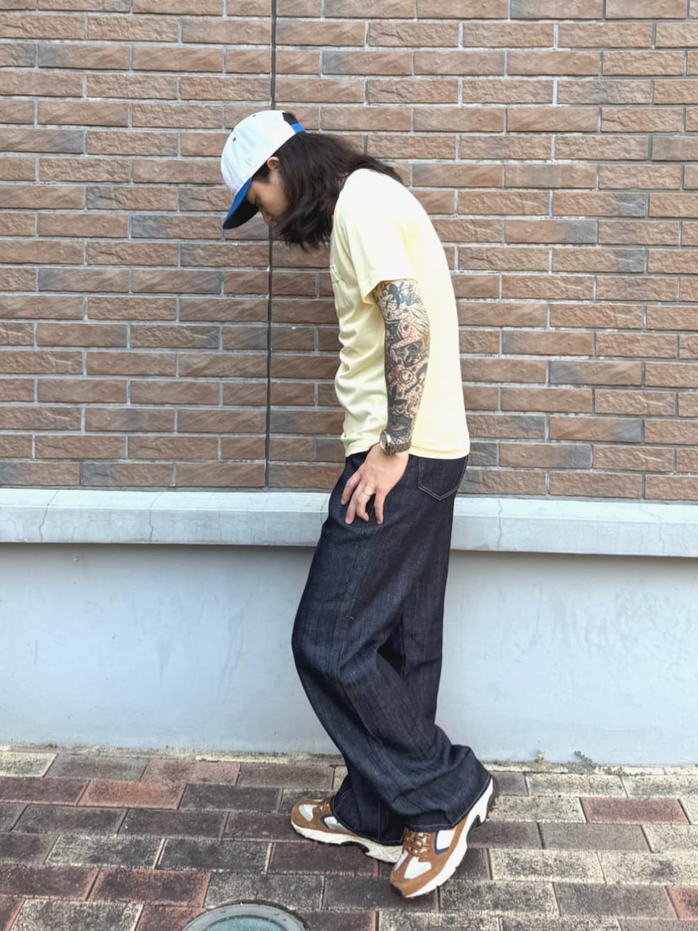 イエロー系のTシャツ/カットソー、ブルー系のデニムパンツを着用したメンズの夏コーディネートの3枚目の写真