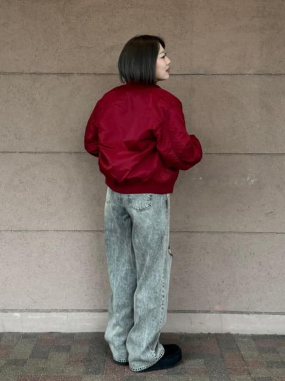 グレー系のデニムパンツ、レッド系のMA-1、グレー系のスウェットを着用したレディースの春コーディネートの2枚目の写真