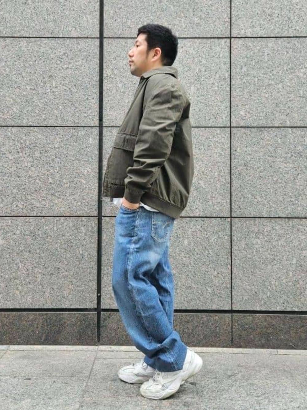 ブルー系のデニムパンツ、グリーン系のブルゾンを着用したメンズの春コーディネートの3枚目の写真