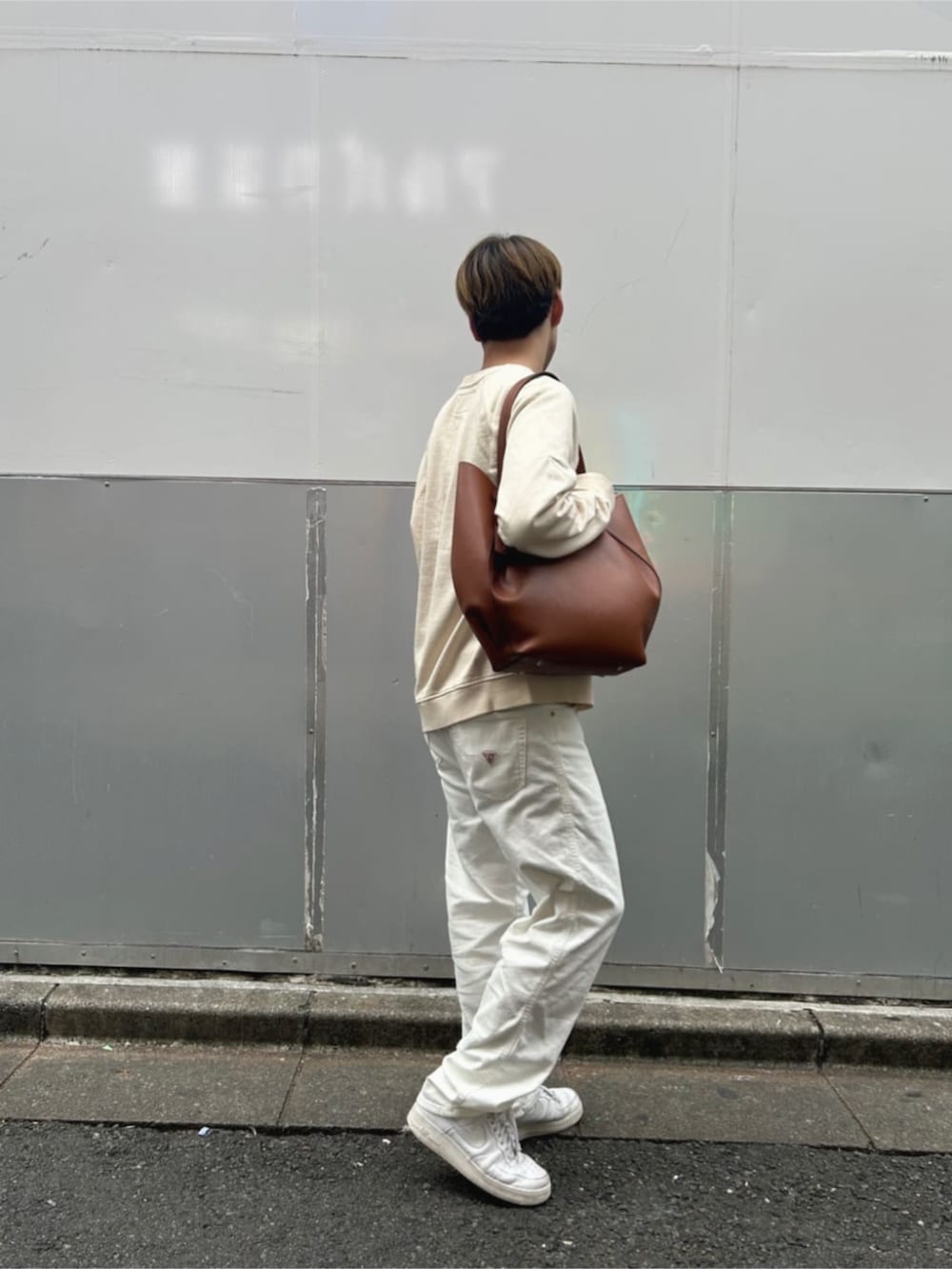 ブラウン系のトートバッグを着用したメンズの秋コーディネートの2枚目の写真