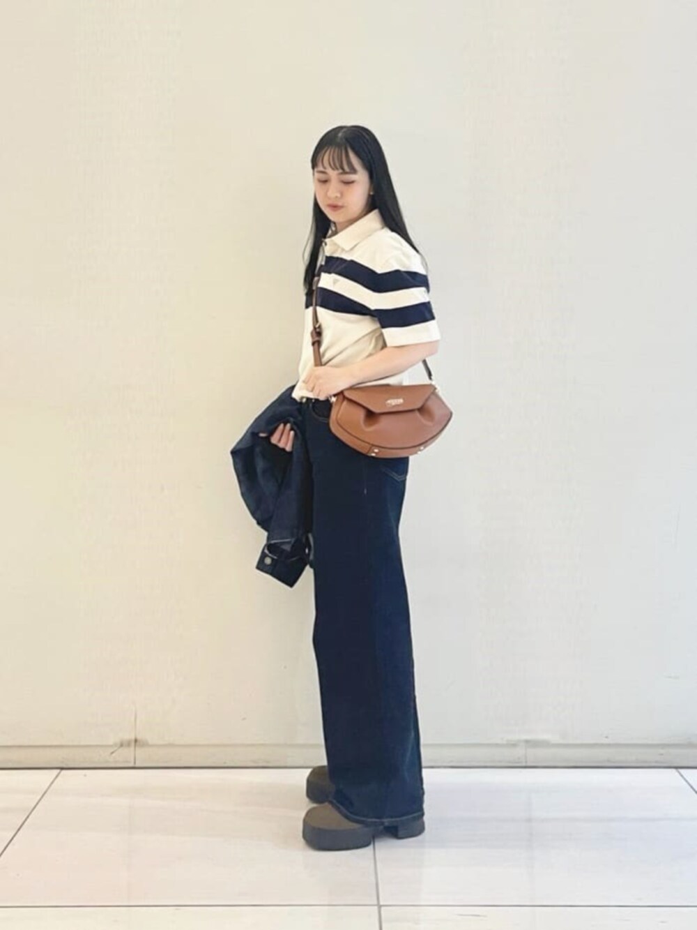 ブルー系のシャツ/ブラウス、ホワイト系のポロシャツ、ブラウン系のショルダーバッグを着用したレディースの秋コーディネートの3枚目の写真