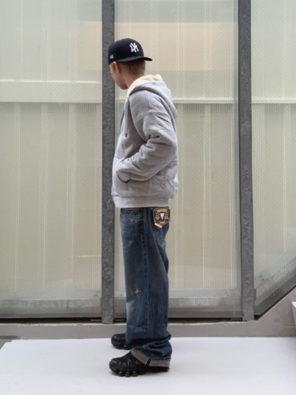 ブラック系のTシャツ/カットソー、ブルー系のデニムパンツ、グレー系のパーカーを着用したメンズの冬コーディネートの3枚目の写真