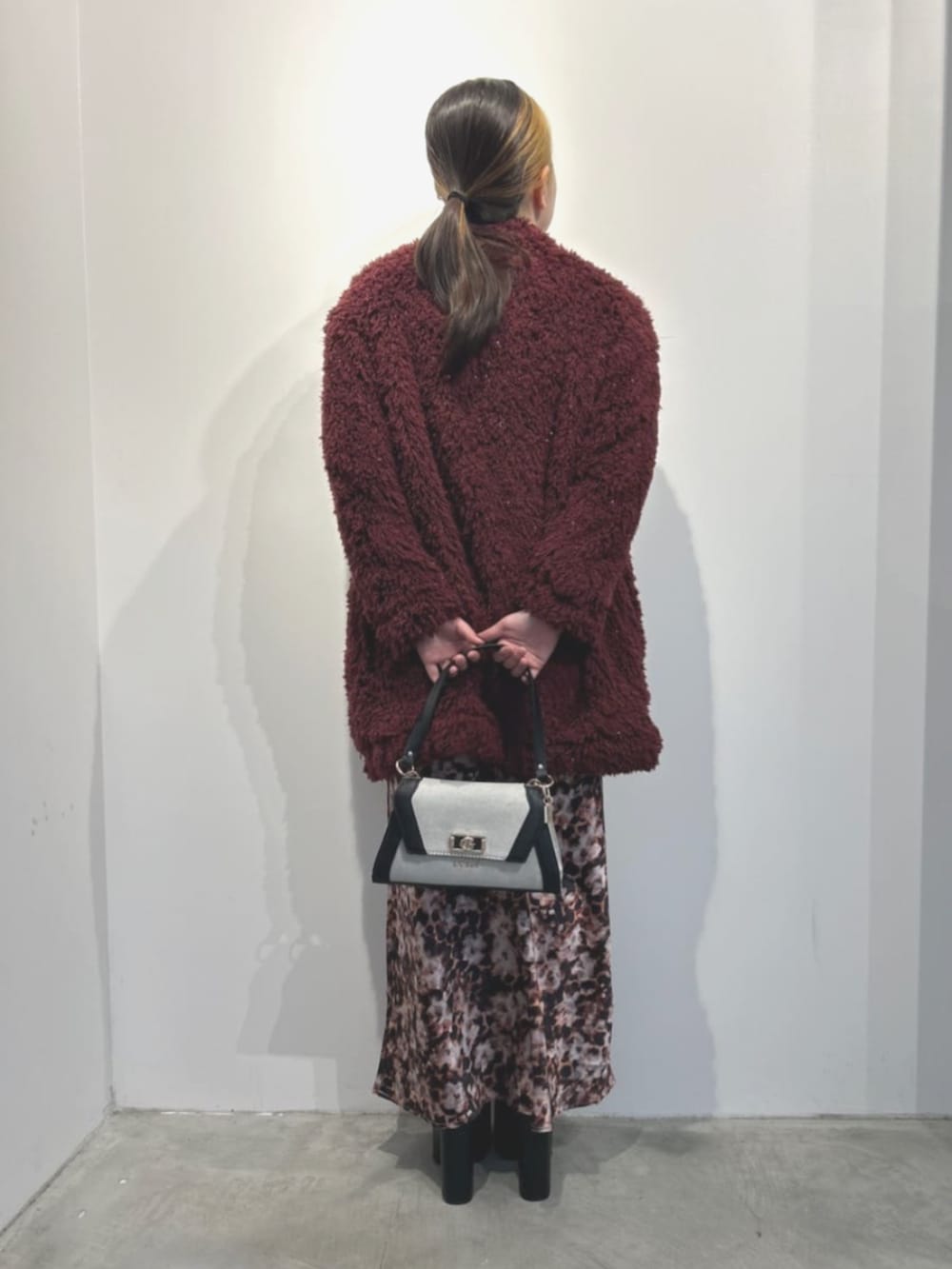 ブラック系のワンピース、ブラック系のショルダーバッグ、レッド系のカーディガン/ボレロを着用したレディースの春コーディネートの2枚目の写真