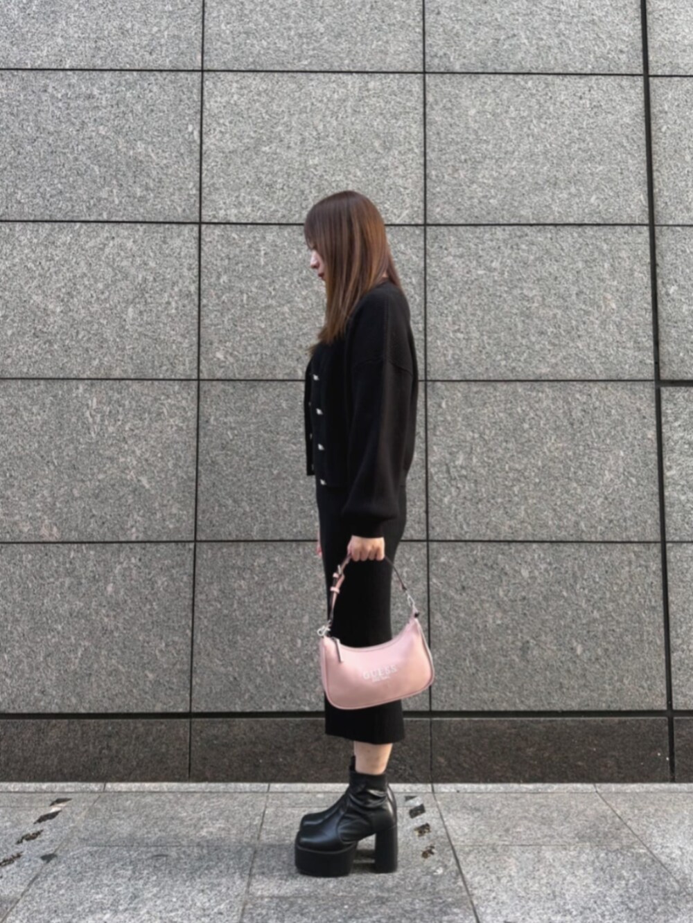 ピンク系のショルダーバッグ、ブラック系のワンピース、ブラック系のカーディガン/ボレロを着用したレディースの冬コーディネートの3枚目の写真