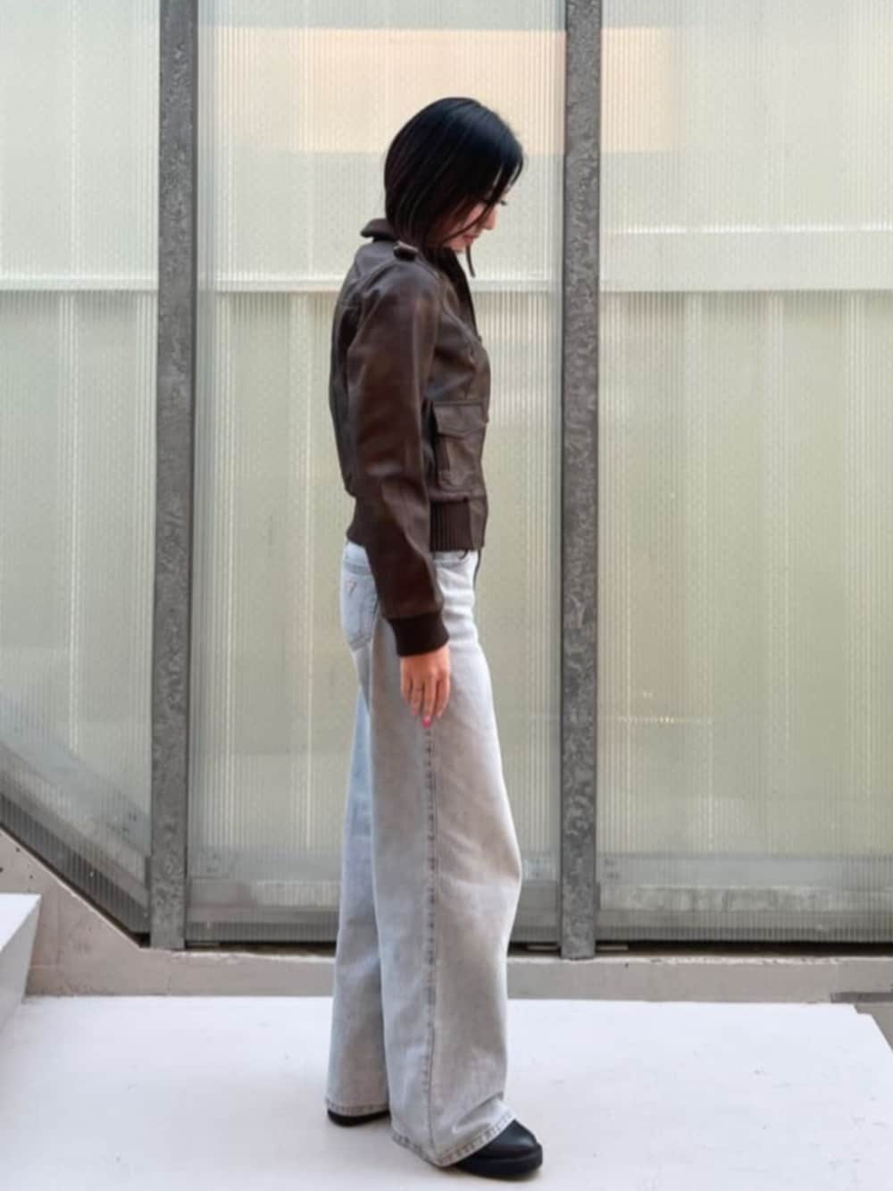 ブルー系のデニムパンツ、ブラウン系のミリタリージャケットを着用したレディースの冬コーディネートの3枚目の写真