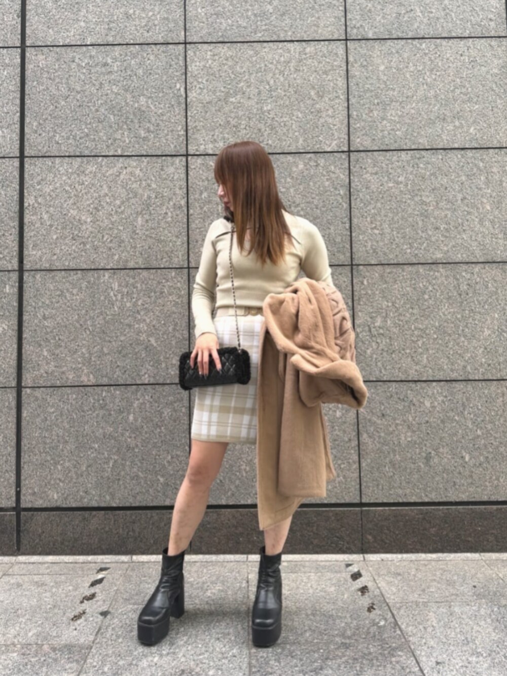 ベージュ系のムートンコート、ブラック系のショルダーバッグ、ホワイト系のワンピースを着用したレディースの冬コーディネートの4枚目の写真