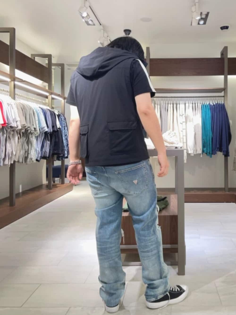 ブルー系のデニムパンツ、シルバー系のブレスレットを着用したメンズの夏コーディネートの2枚目の写真