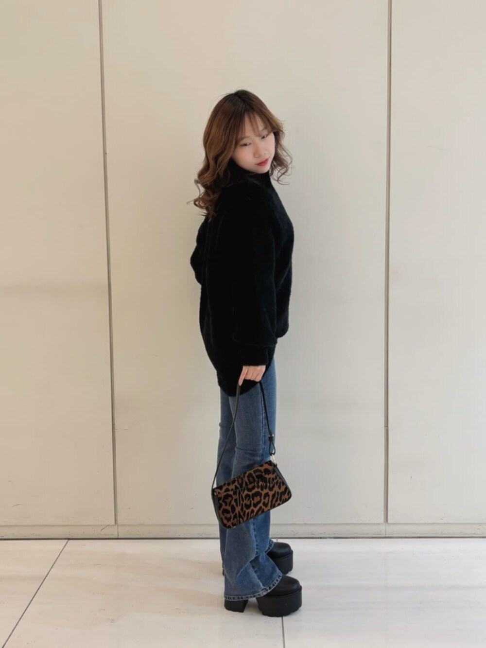 ブルー系のデニムパンツ、ブラック系のニット/セーター、その他のハンドバッグを着用したレディースの冬コーディネートの3枚目の写真