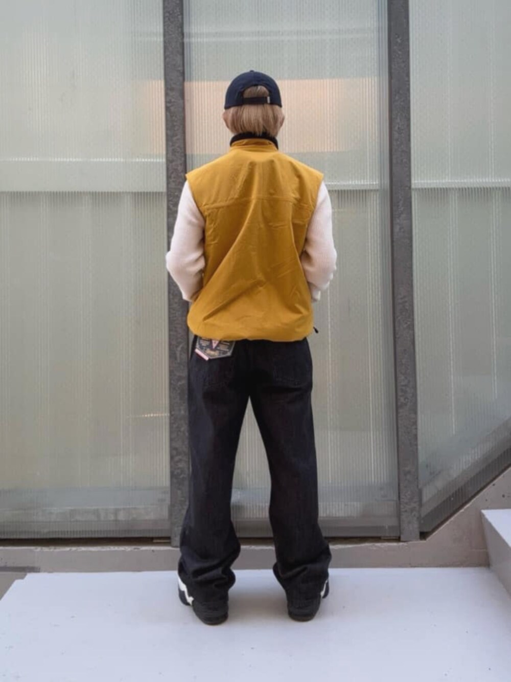 ブラック系のデニムパンツ、イエロー系のベスト、その他のボクサーパンツを着用したメンズの秋コーディネートの5枚目の写真