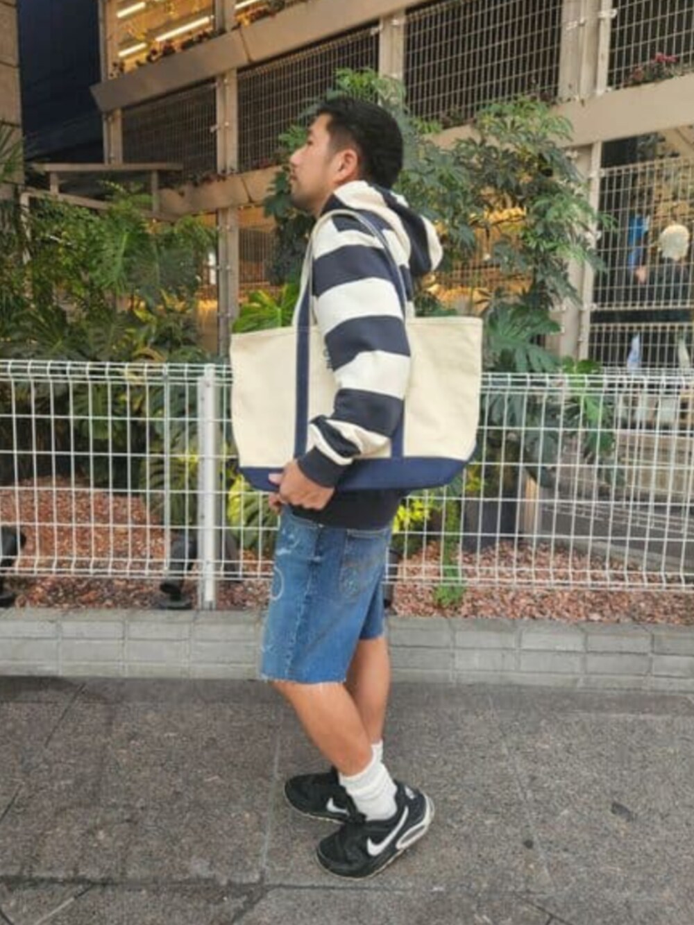 ブルー系のパーカー、ブルー系のトートバッグを着用したメンズの秋コーディネートの2枚目の写真