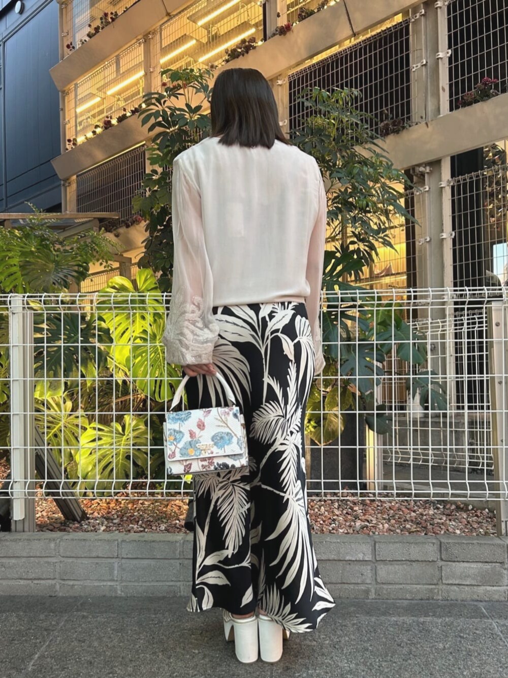 ブラック系のワンピース、ベージュ系のシャツ/ブラウス、ホワイト系のショルダーバッグを着用したレディースの夏コーディネートの2枚目の写真