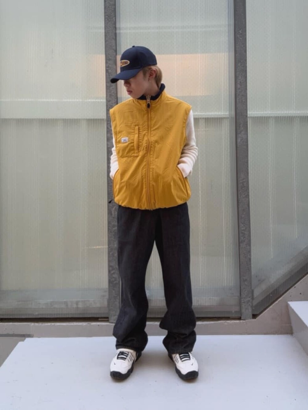 ブラック系のデニムパンツ、イエロー系のベスト、その他のボクサーパンツを着用したメンズの秋コーディネートの4枚目の写真