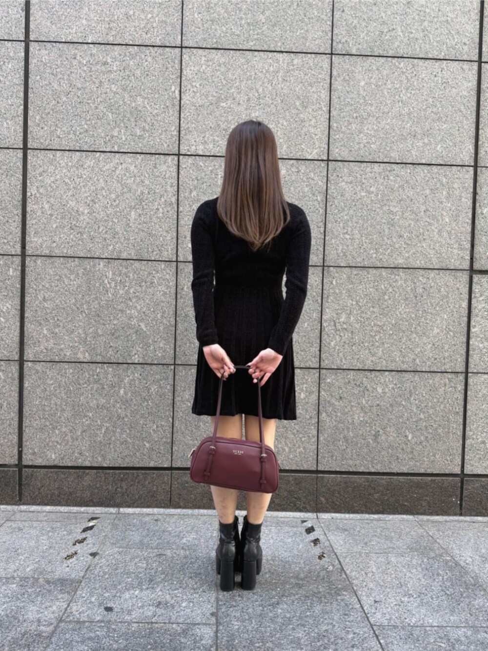 レッド系のショルダーバッグ、ブラック系のワンピースを着用したレディースの秋コーディネートの2枚目の写真