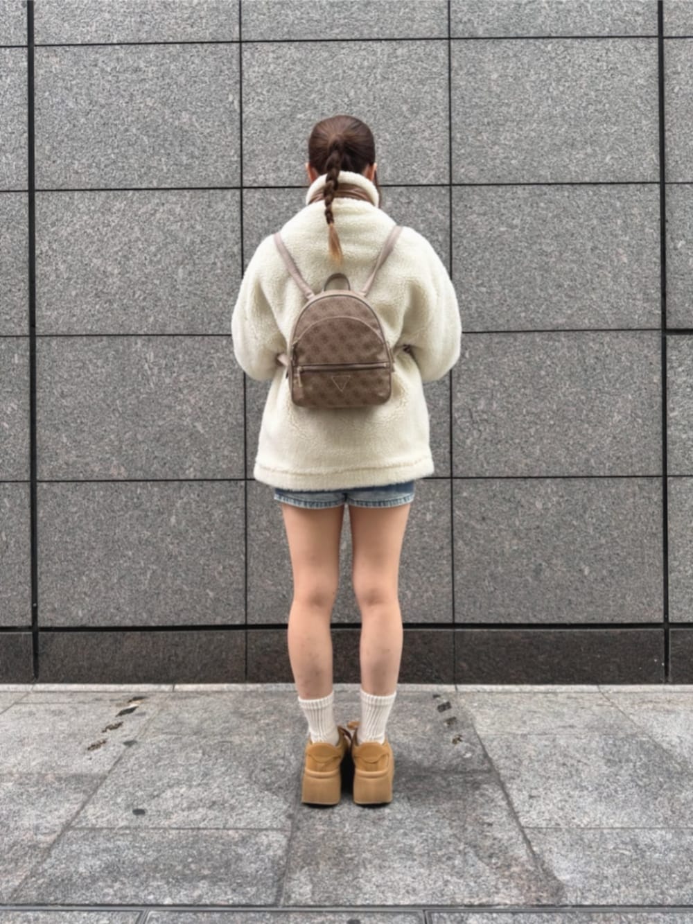 ベージュ系のバックパック/リュック、ホワイト系のその他アウター、ブルー系のデニムパンツを着用したレディースの冬コーディネートの2枚目の写真