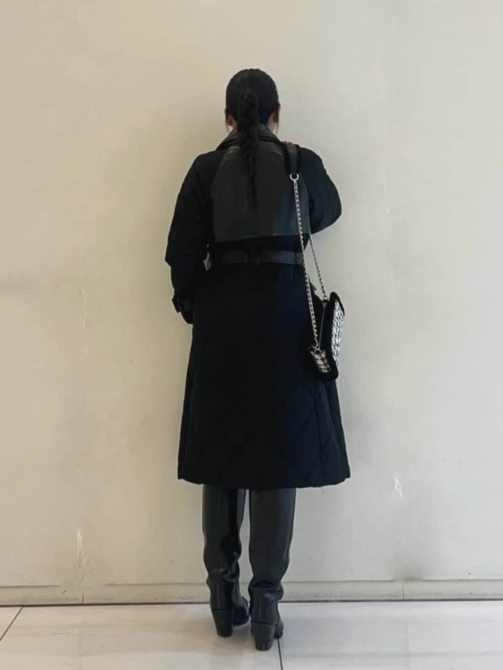 ブラック系のトレンチコート、ブルー系のデニムパンツ、ブラック系のショルダーバッグを着用したレディースの冬コーディネートの2枚目の写真