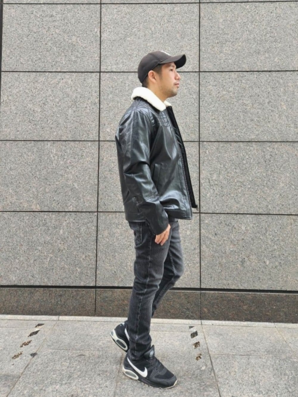 グレー系のデニムパンツ、ブラック系のムートンコートを着用したメンズの秋コーディネートの3枚目の写真