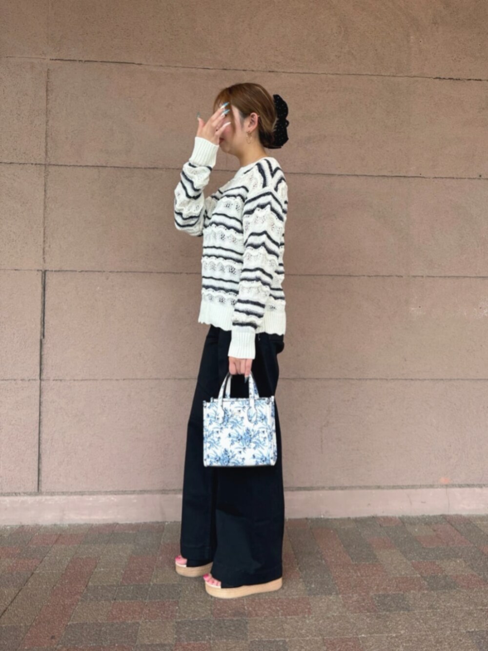 ブラック系のデニムパンツ、ホワイト系のショルダーバッグ、ホワイト系のニット/セーターを着用したレディースの秋コーディネートの3枚目の写真