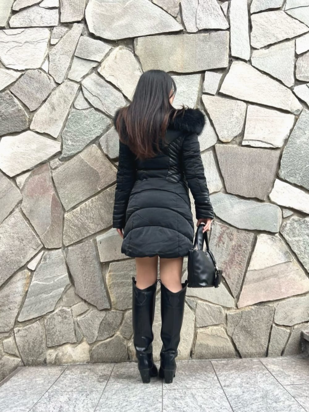 ブラック系のニット/セーター、ブラック系のトートバッグ、ブラック系のダウンジャケット/コートを着用したレディースの秋コーディネートの2枚目の写真