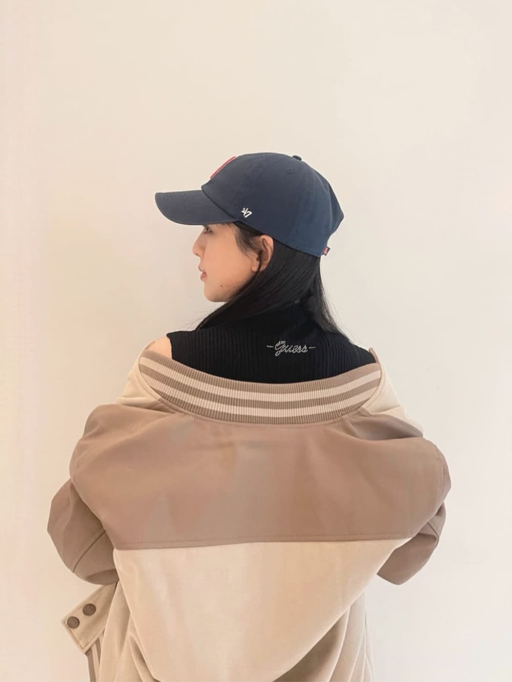 ブラック系のワンピース、ブラック系のトートバッグ、ベージュ系のスタジャンを着用したレディースの秋コーディネートの5枚目の写真