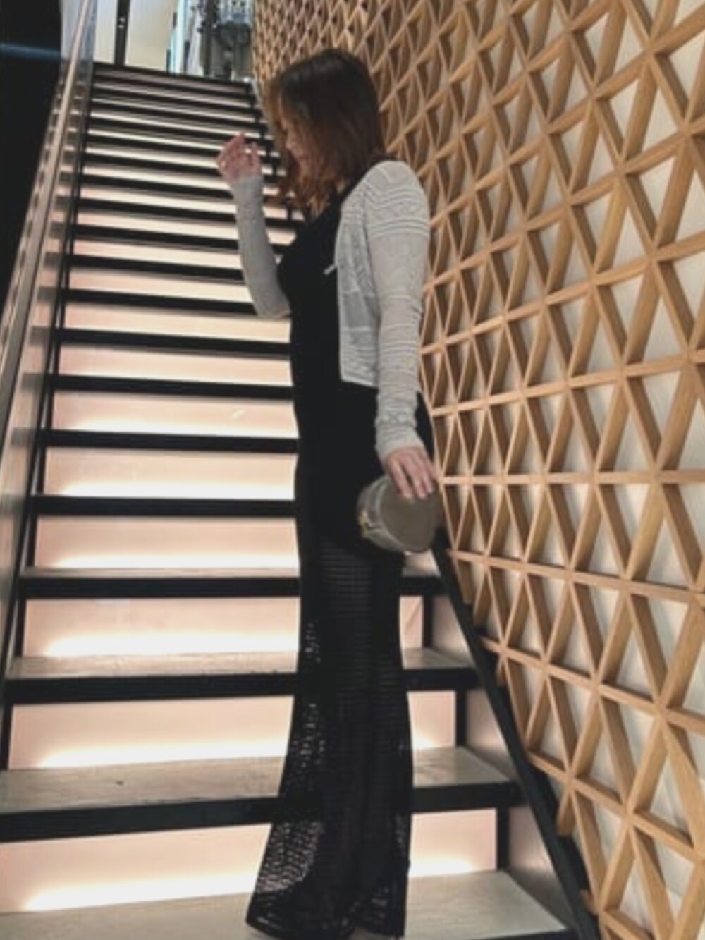 グレー系のショルダーバッグ、ブラック系のワンピース、ホワイト系のカーディガン/ボレロを着用したレディースの夏コーディネートの3枚目の写真