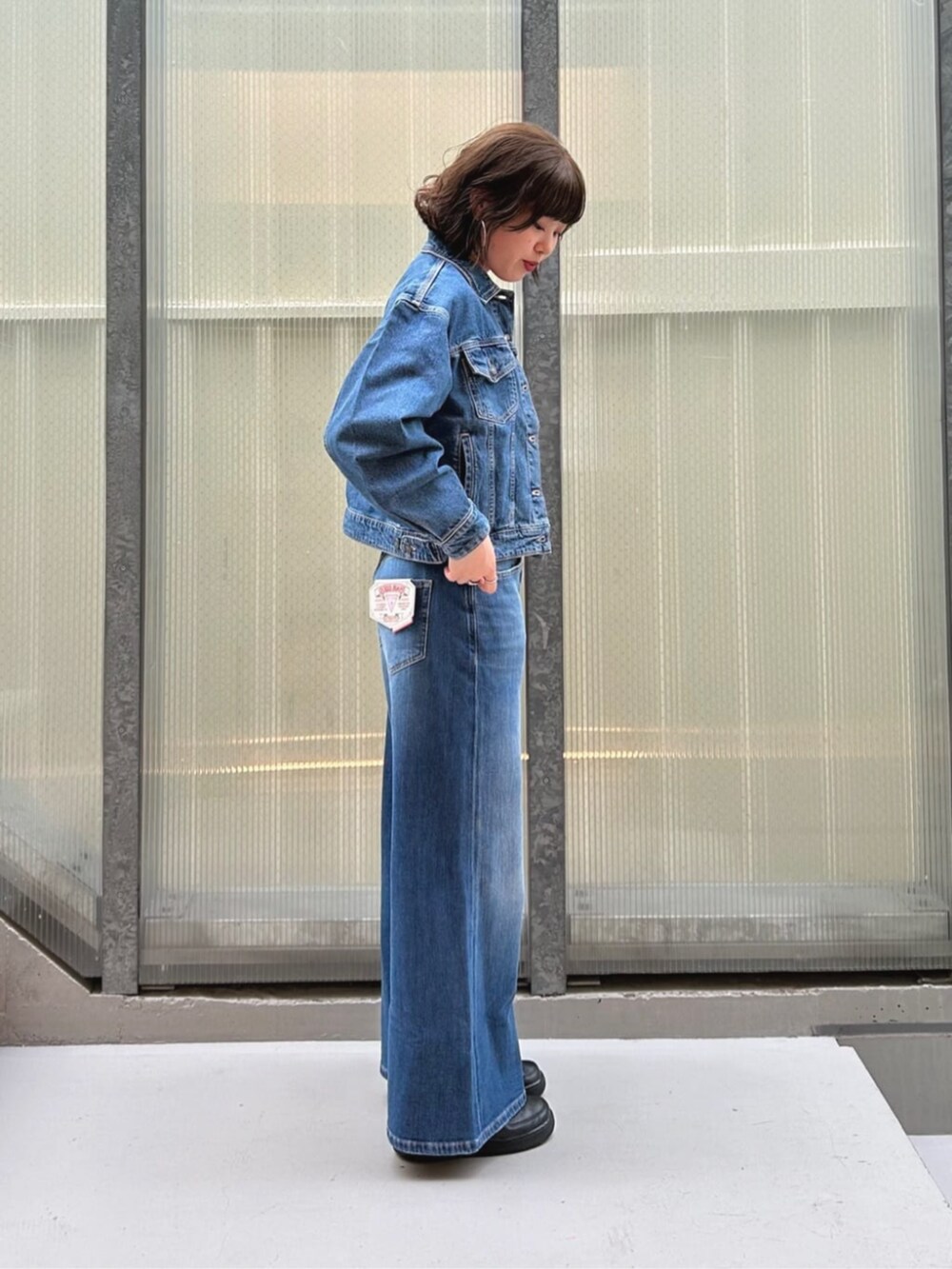 ブルー系のデニムパンツ、ピンク系のTシャツ/カットソー、ブルー系のデニムジャケットを着用したレディースの秋コーディネートの3枚目の写真