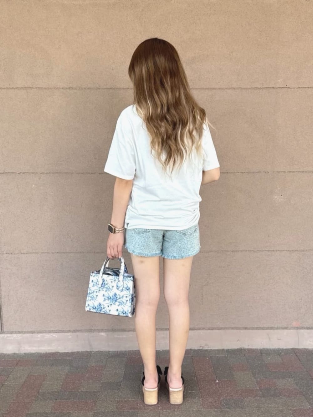 ホワイト系のショルダーバッグ、ブルー系のデニムパンツ、ホワイト系のTシャツ/カットソーを着用したレディースの夏コーディネートの2枚目の写真