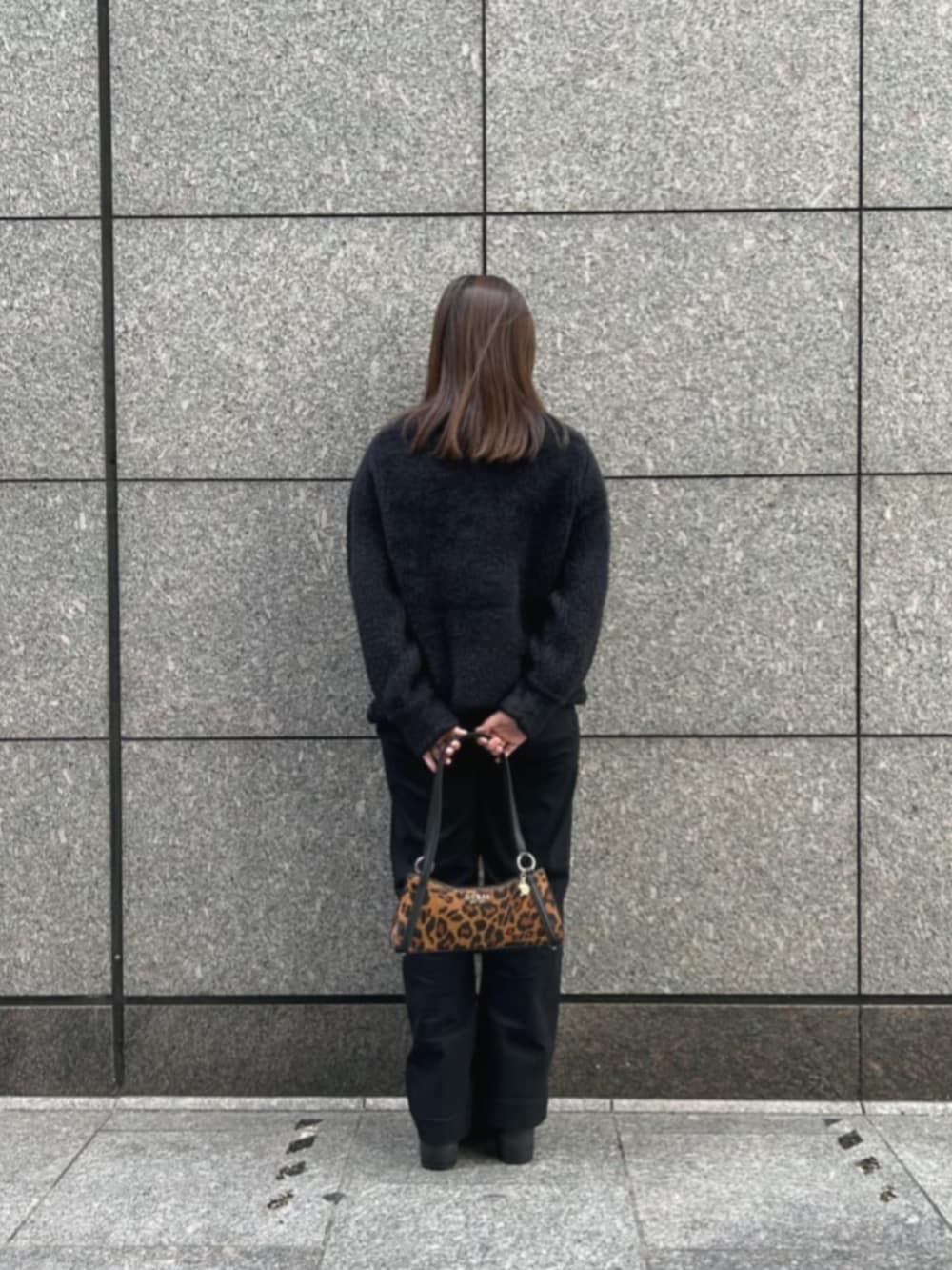 ブラック系のデニムパンツ、ブラック系のニット/セーター、その他のハンドバッグを着用したレディースの冬コーディネートの2枚目の写真