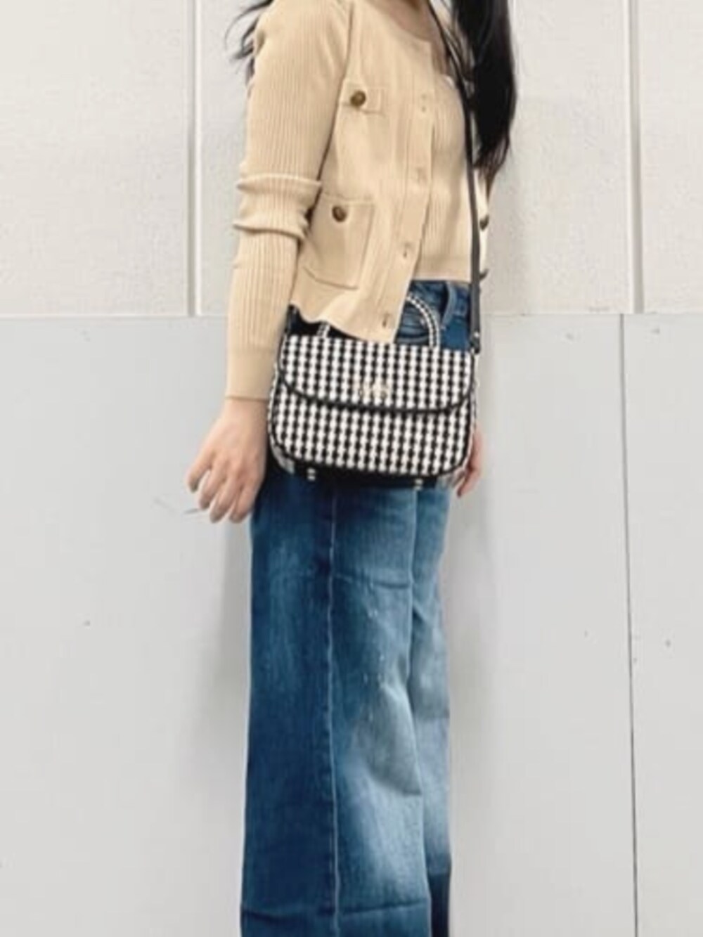 ベージュ系のカーディガン/ボレロ、ブルー系のデニムパンツ、ブラック系のショルダーバッグを着用したレディースの秋コーディネートの4枚目の写真