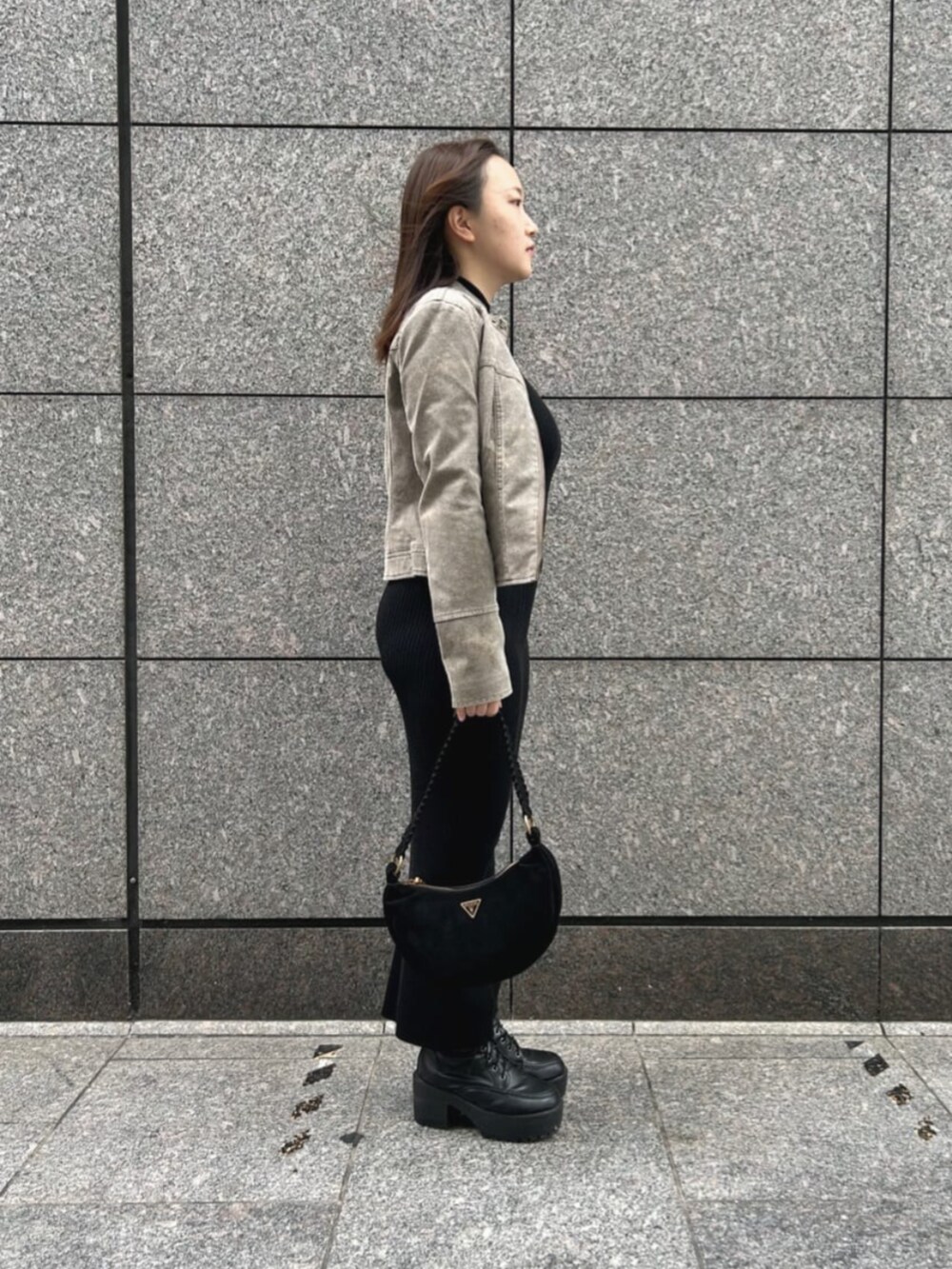 ブラック系のショルダーバッグ、ベージュ系のノーカラージャケット、ブラック系のワンピースを着用したレディースの秋コーディネートの3枚目の写真