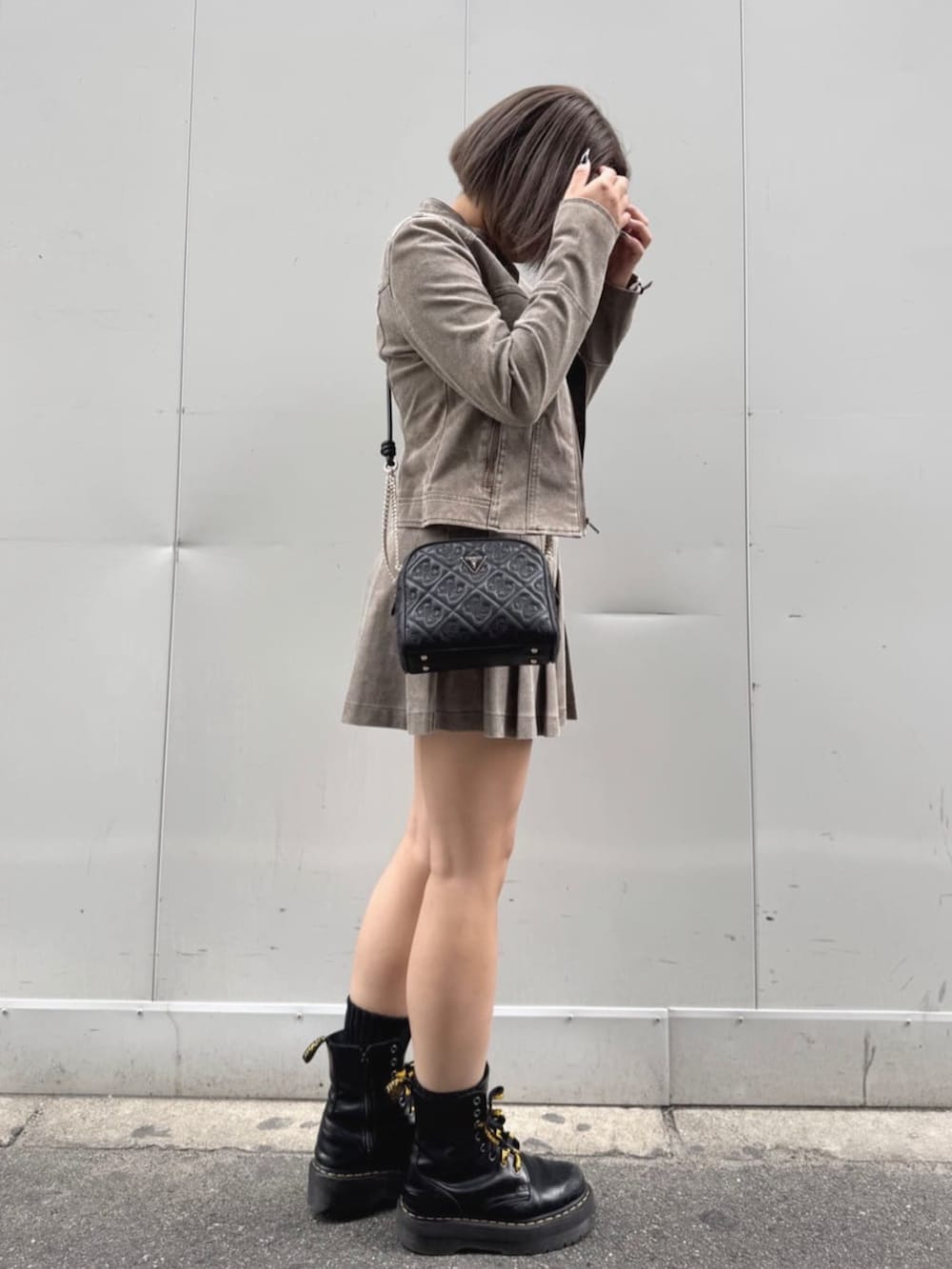 ベージュ系のノーカラージャケット、ベージュ系のスカート、ブラック系のニット/セーターを着用したレディースの秋コーディネートの3枚目の写真