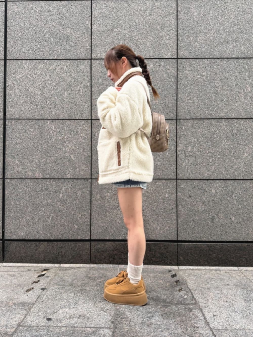 ベージュ系のバックパック/リュック、ホワイト系のその他アウター、ブルー系のデニムパンツを着用したレディースの冬コーディネートの3枚目の写真