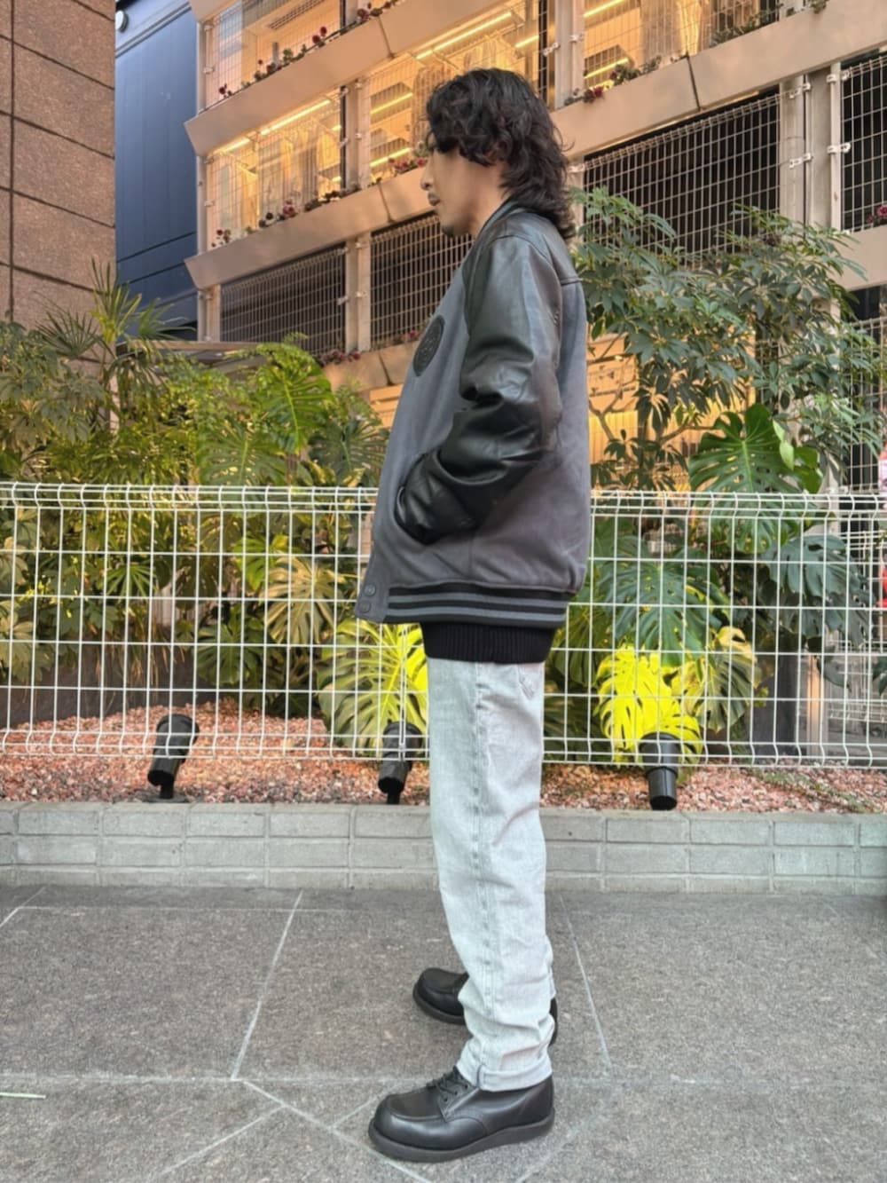 グレー系のデニムパンツ、グレー系のスタジャンを着用したメンズの秋コーディネートの3枚目の写真