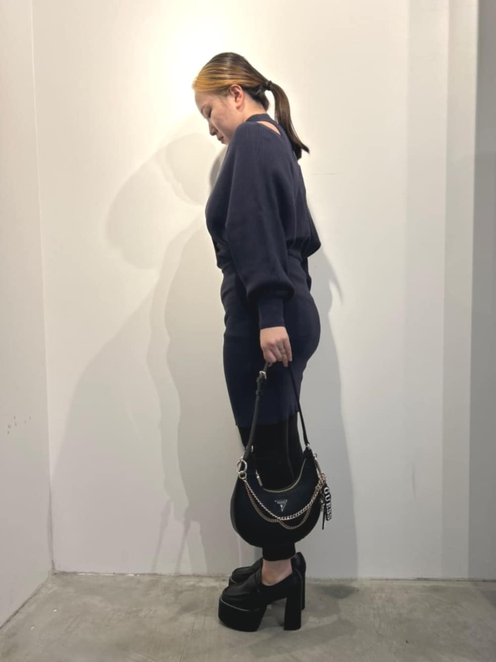 ブルー系のワンピース、ブラック系のショルダーバッグを着用したレディースの冬コーディネートの3枚目の写真