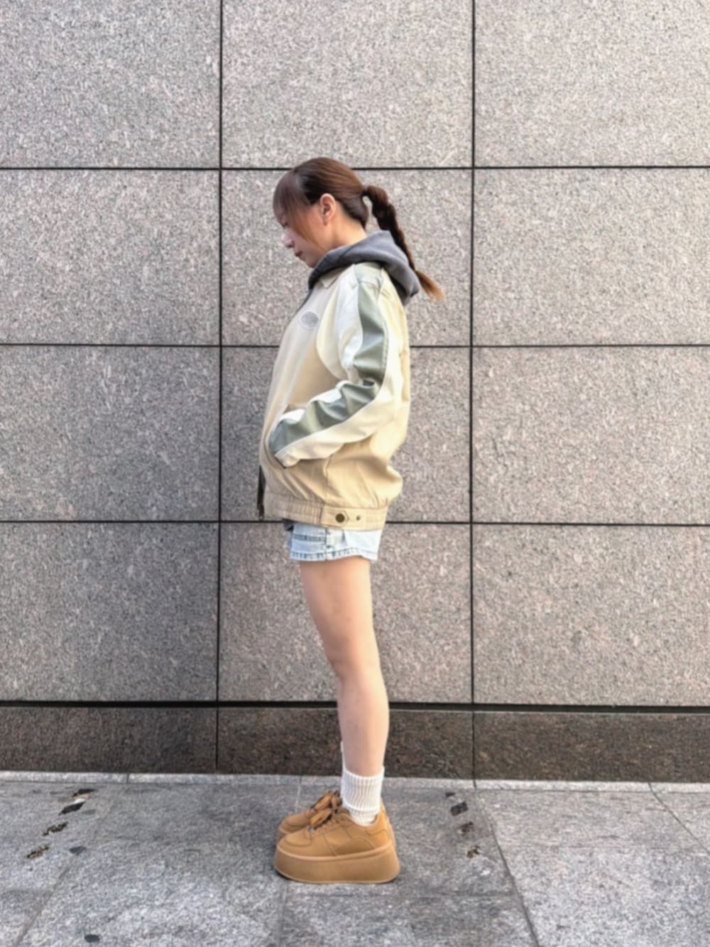 グレー系のパーカー、ブルー系のデニムパンツ、ベージュ系のその他アウターを着用したレディースの冬コーディネートの3枚目の写真