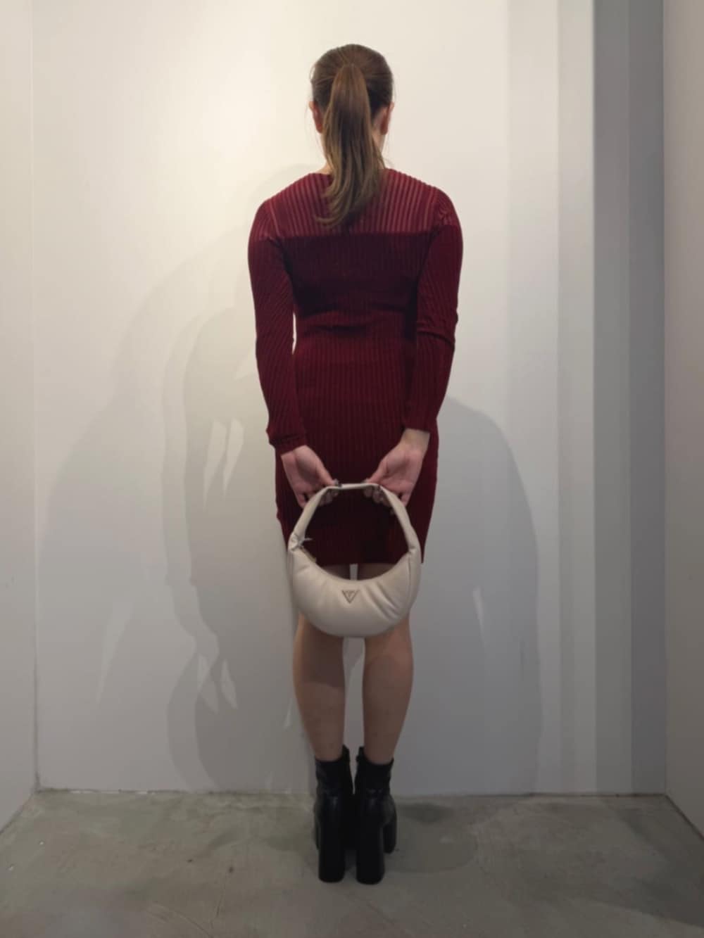 ホワイト系のショルダーバッグ、レッド系のワンピースを着用したレディースの冬コーディネートの2枚目の写真