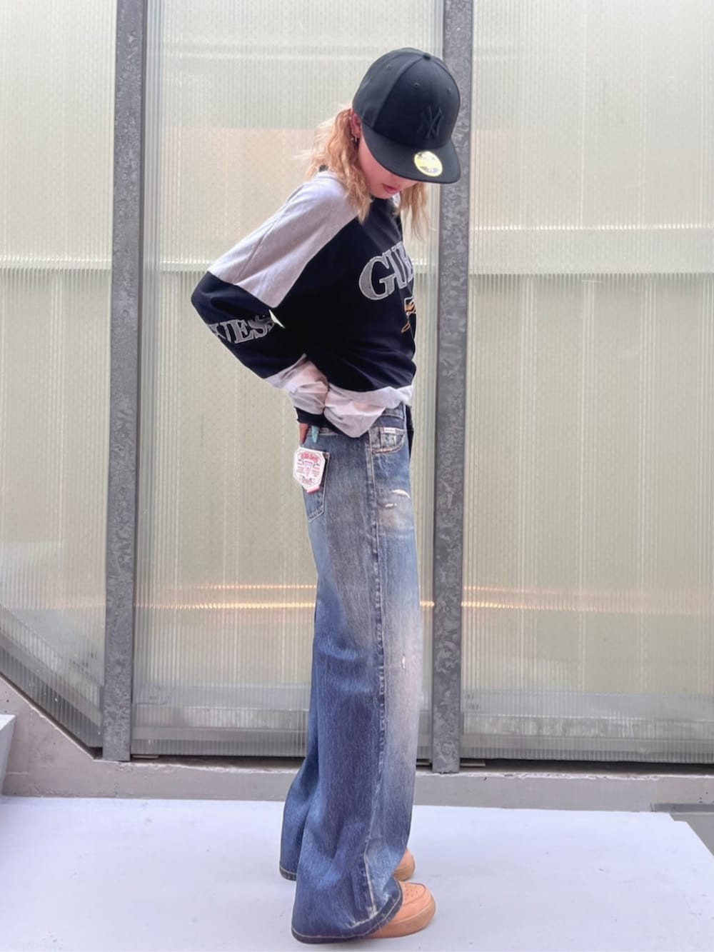 ブラック系のスウェット、ブルー系のデニムパンツを着用したレディースの夏コーディネートの4枚目の写真