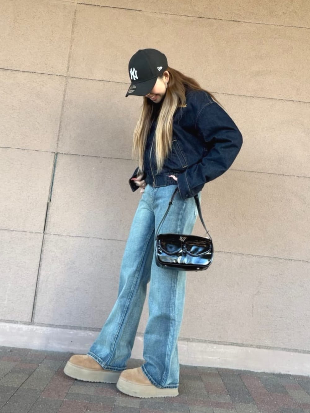 ブルー系のデニムジャケット、ブラック系のショルダーバッグ、ブルー系のデニムパンツを着用したレディースの春コーディネートの3枚目の写真