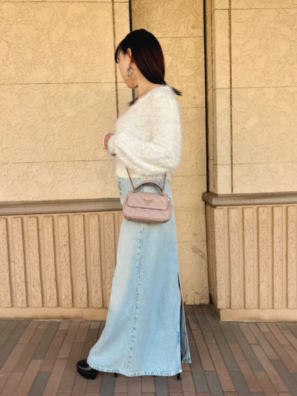 ピンク系のショルダーバッグ、ブルー系のデニムスカート、その他のカーディガン/ボレロを着用したレディースの冬コーディネートの3枚目の写真