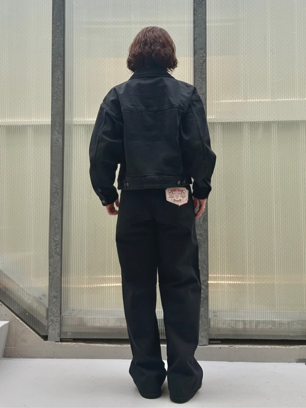 ブルー系のデニムパンツ、ホワイト系のキャミソール、ブルー系のデニムジャケットを着用したレディースの夏コーディネートの2枚目の写真