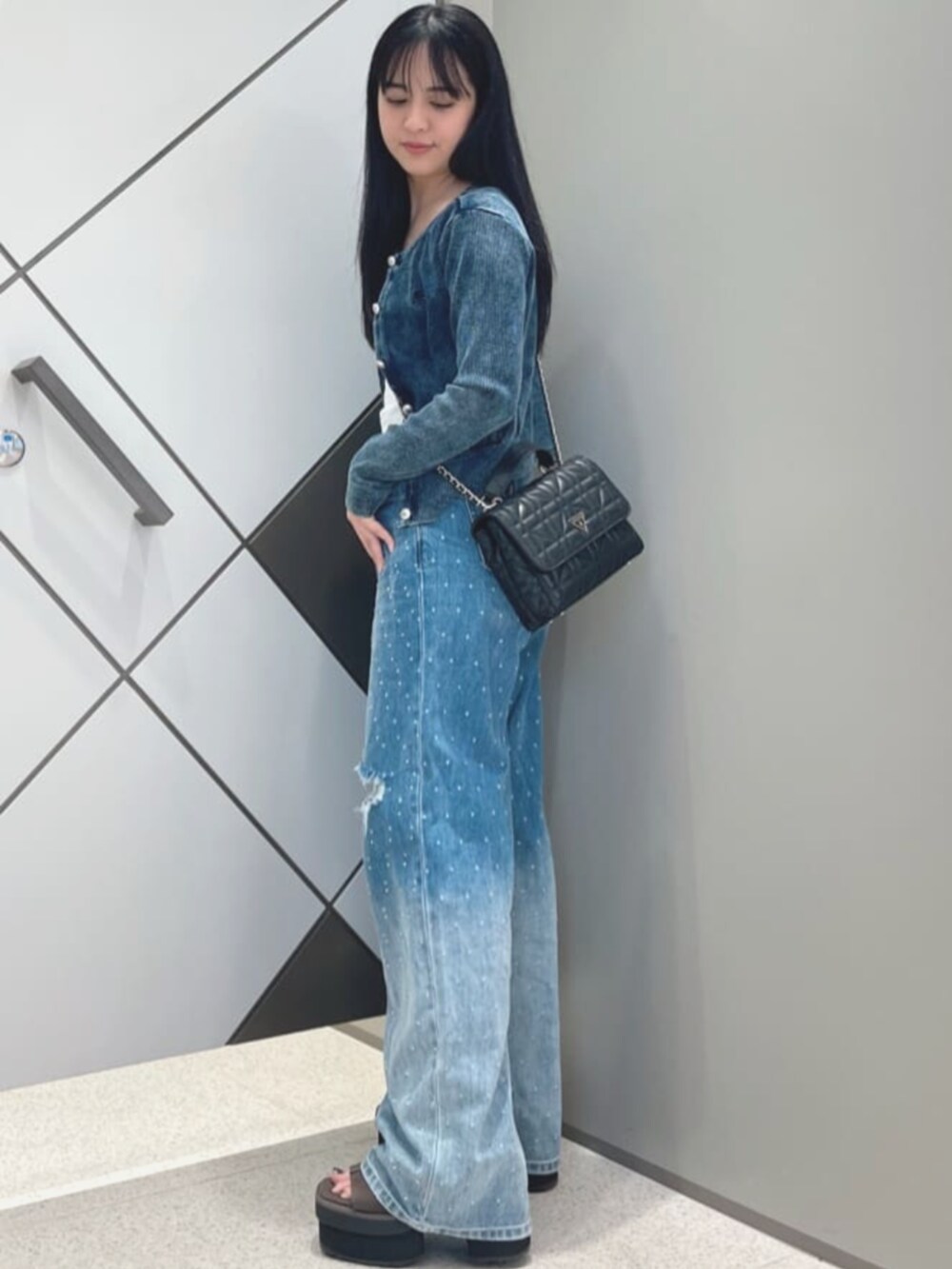 ブルー系のデニムパンツ、ブルー系のカーディガン/ボレロ、ホワイト系のタンクトップを着用したレディースの夏コーディネートの3枚目の写真