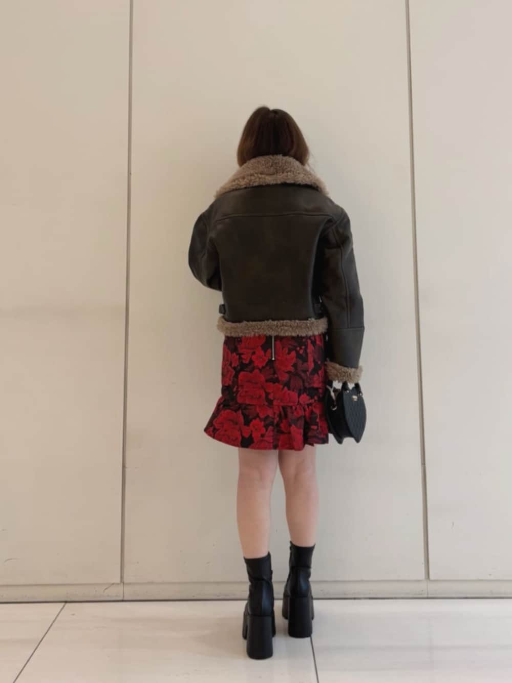 ブラック系のショルダーバッグ、ブラウン系のライダースジャケット、その他のワンピースを着用したレディースの冬コーディネートの2枚目の写真