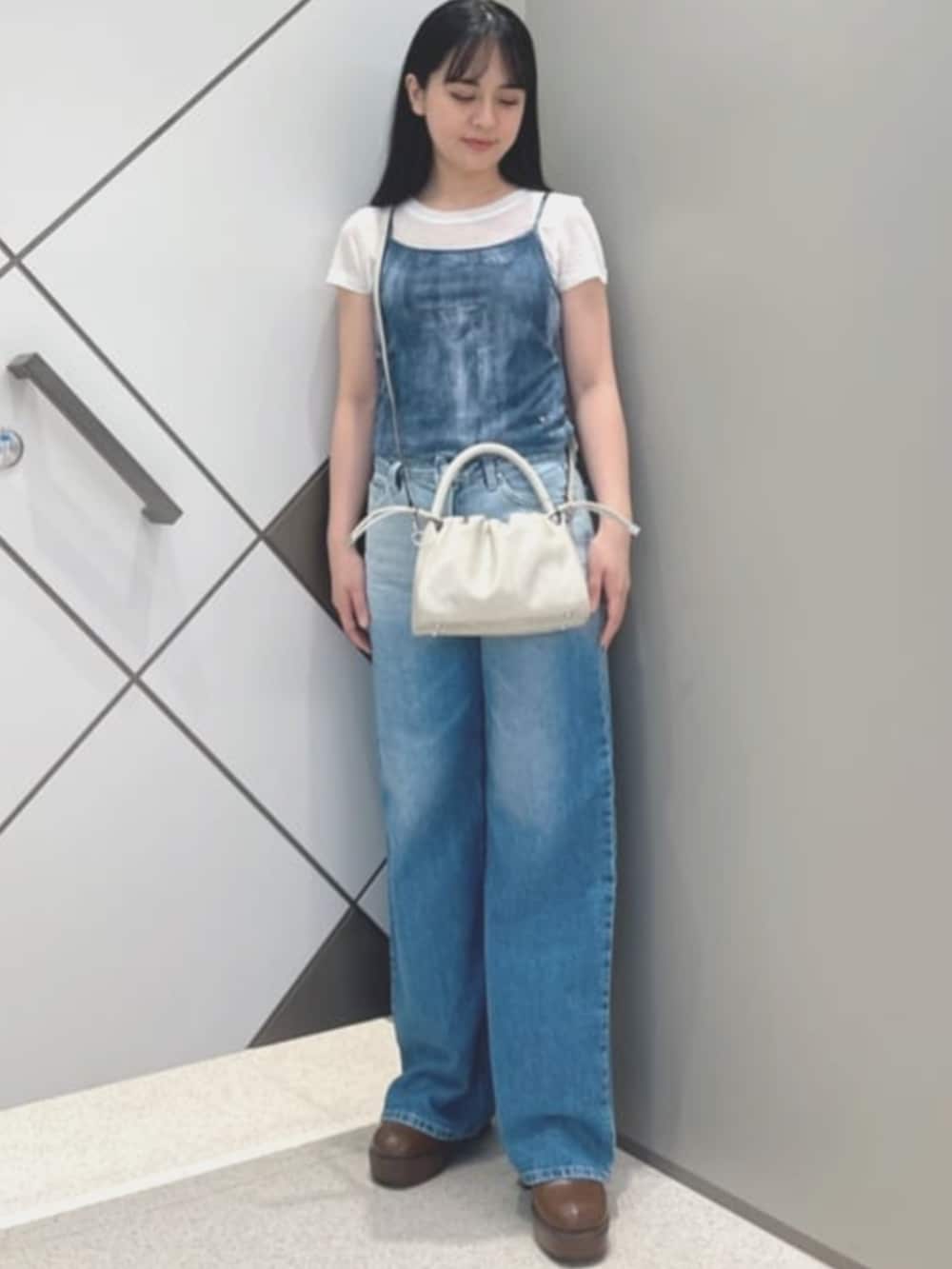 ベージュ系のショルダーバッグ、ホワイト系のその他トップス、ブルー系のデニムパンツを着用したレディースの夏コーディネートの4枚目の写真